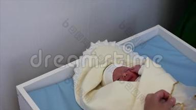 母亲在分娩后把新生<strong>婴儿襁褓中</strong>. 新生儿出生后躺在床上，看着